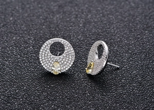 Detailed shot of S925 silver stud earrings with yellow pear-shaped stone and pave setting