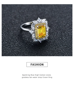 Macro d'une bague jaune taille Asscher avec halo marquise sur fond noir texturé