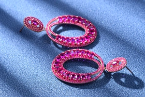 Macro shot of rose gold earrings with oval pink tourmaline and white diamond pavé