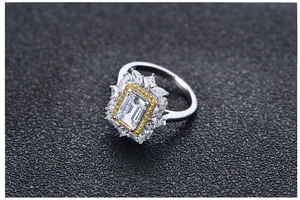 Vue macro d'une pierre jaune taille Asscher avec halo rayonnant sur bague en argent