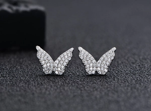 Dettaglio macro di orecchini a farfalla in argento con micro-pave di zirconi cubici