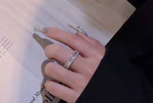 Detailed view of S925 sterling silver ring with baguette-cut zircon row inlay on a finger