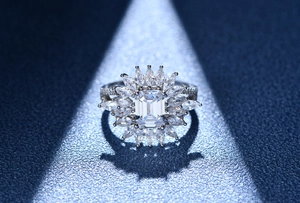 Macro detail of 925 sterling silver ring with emerald cut center stone and marquise halo