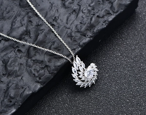 Macro shot of a spiral silver pendant with sparkling diamonds on a dark stone background