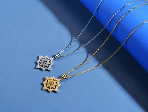 Dettaglio delle collane a stella in oro e argento con pietre preziose verdi centrali