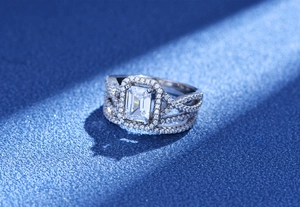 Détail macro de la bague halo taille émeraude avec anneaux pavés de zircone entrelacés