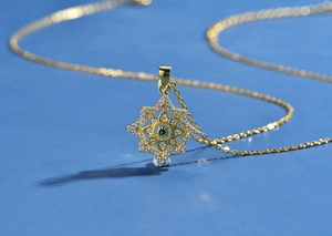 Dettaglio collana stella argento 925 oro 18k con zirconi bianchi e gemma verde