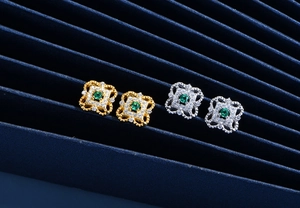 Detailed view of vintage square stud earrings in gold and silver with green gemstones