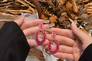 Detailed view of luxury rose gold earrings with pave-set pink oval gemstones