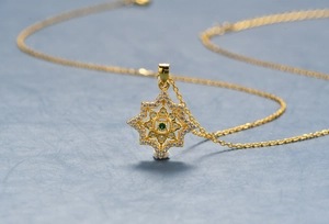 Dettaglio della collana in argento placcato oro 18k con stella e pietra verde