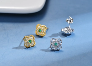 Detail of square hollow 925 silver clover earrings with green emeralds and zircon pavé