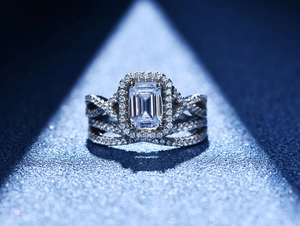 Détail macro d'une bague taille émeraude avec halo et anneau pavé multicouche étincelant