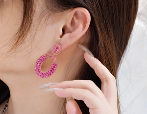 Detailed view of large oval pink tourmaline earrings on model with rose gold finish