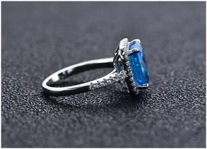 Macro side view of 925 silver ring featuring a large radiant cut blue gemstone and diamonds