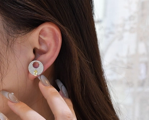 Close-up of S925 silver round pavé stud earrings with a yellow pear-cut gemstone drop
