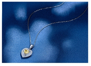Macro shot of 925 silver necklace featuring a heart-shaped yellow gemstone pendant