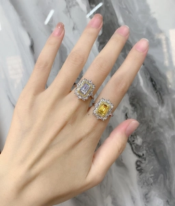 Détail de bagues jaunes et blanches taille émeraude avec halo diamants sur argent