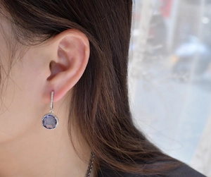 Detailed close-up of 11mm round purple zircon earrings with S925 sterling silver settings