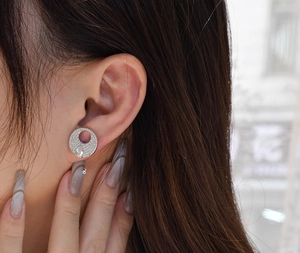 Detailed view of S925 sterling silver ear studs with pear-cut center stone on ear lobe