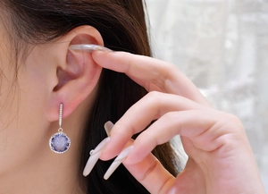 Macro detail of round purple druzy drop earrings with sparkling zircon halo on model