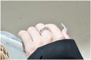 Detail of silver chain link ring with pavé-set stones worn on the finger