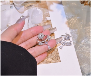 Detailed view of silver drop fringe earrings with hexagonal and teardrop zircons