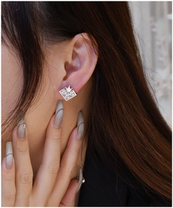 Detail of silver crown heart stud earring worn on ear with high-carbon diamond sparkle
