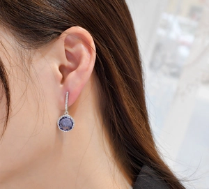 Detail of 11mm purple carbon diamond earring on ear with sterling silver micro-pave setting