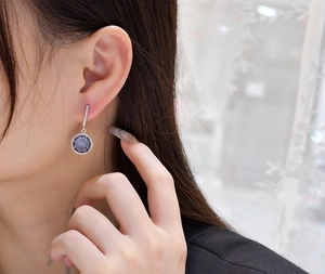Close-up of 11mm purple diamond earrings on ear, featuring S925 silver and pave crystals