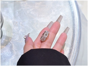 Close-up of interlocking 925 silver chain ring with baguette cut zirconias on finger