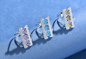 Detail of 925 silver bridge rings featuring pink, blue, and yellow gemstone settings