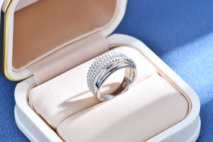 Close-up of S925 sterling silver ring with pavé diamonds in a beige velvet jewelry box