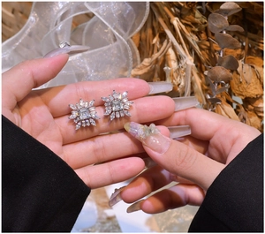 Gros plan détaillé de boucles d'oreilles flocon en argent S925 avec pierres taille émeraude