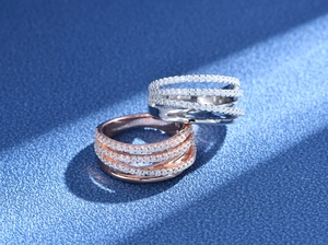 Macro shot of silver and rose gold multi-layer crisscross rings with pavé cubic zirconia