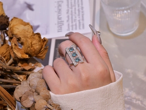 Detail of s925 sterling silver ring with blue gemstones on hand in a lifestyle setting