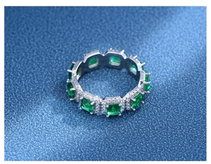 Detaillierte Draufsicht auf einen Eternity-Ring mit Smaragden und Zirkonia-Akzenten