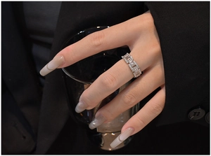 Detail of silver chain ring with rectangular zircon shown on a model's finger