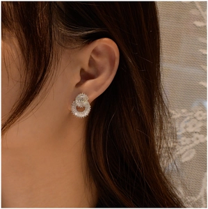 Close-up of 925 sterling silver double-circle earrings with square zircon on earlobe