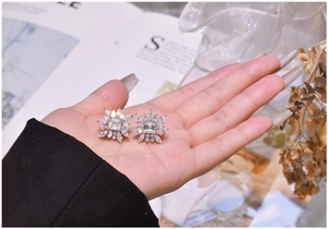 Gros plan de boucles d'oreilles fleur en argent S925 avec détails de diamants