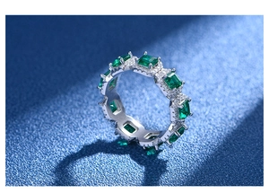Nahaufnahme von Smaragdschliff-Edelsteinen mit Pavé-Fassung auf einem Silberringband