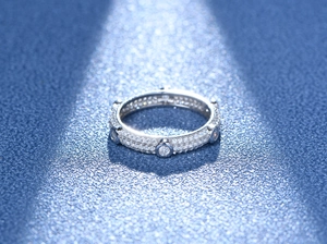Vue macro d'une bague multi-rangs sertie de zircons sur fond bleu profond