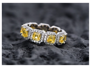 Makroansicht des Eternity-Rings mit gelben Smaragdschliff-Steinen und Halo-Diamanten