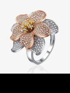 Dettaglio macro dell'anello a fiore in argento S925 con petali in oro rosa e zirconi