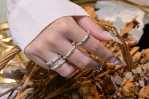 Détail de quatre bagues superposées en argent 925 avec micro-pavage dans un décor vintage