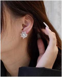 Gros plan de boucles d'oreilles flocon en argent S925 avec zircons brillants sur mannequin