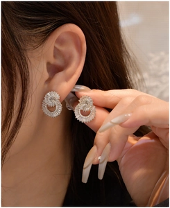 Close-up of double-circle silver earrings with sparkling zircon crystals on model