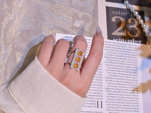 Detail of 925 silver bridge ring with vertical orange stones on a model's hand
