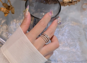 Close-up of a layered S925 silver ring featuring intertwined bands with micro-pave crystals