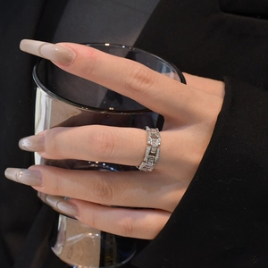 Elegant silver chain link ring with baguette-cut cubic zirconia on a model's finger