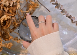 Détail d'une bague en argent 925 avec micro-pavage de zircons portée sur le doigt d'une femme